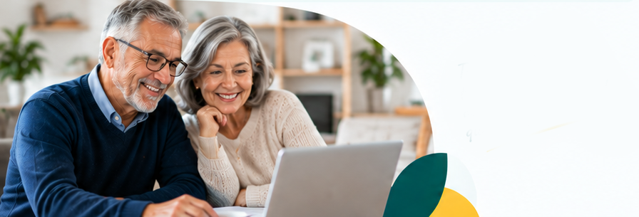 Pareja de pensionados sonriendo frente al computador